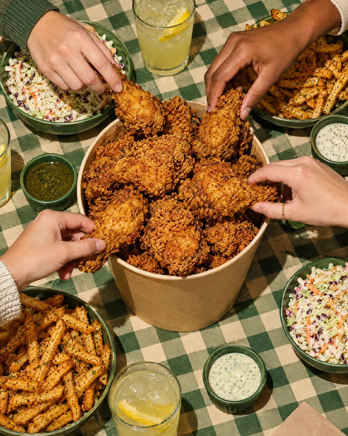 Big bucket of fried chicken in the middle of a party table